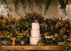Mesa de bolo com arranjos de flores